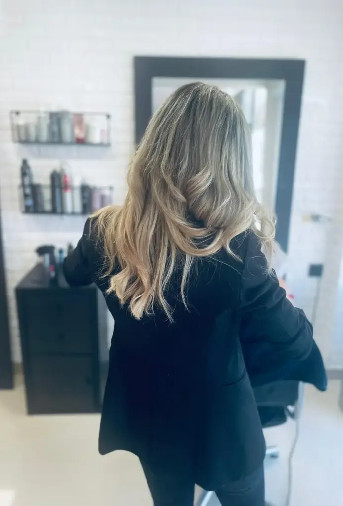 Clienta en el salón luciendo melena rubia con ondas