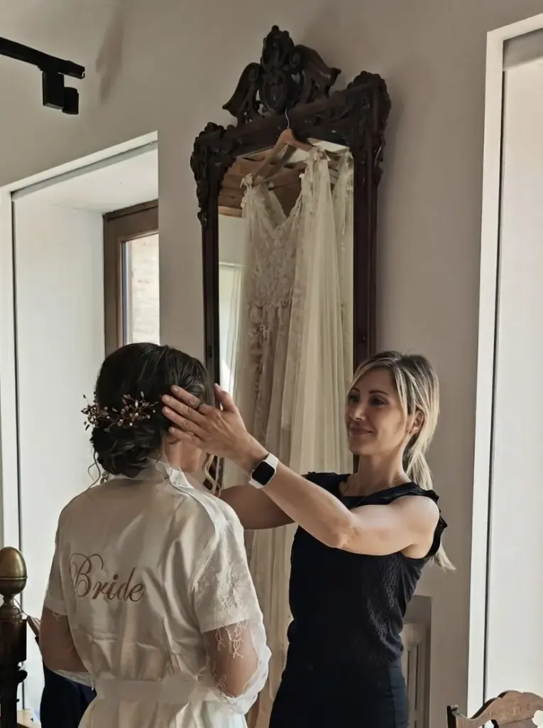 Laura colocando el tocado a una novia en el salón antes de la boda