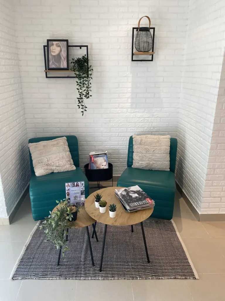 Zona de espera con sillones verdes y plantas