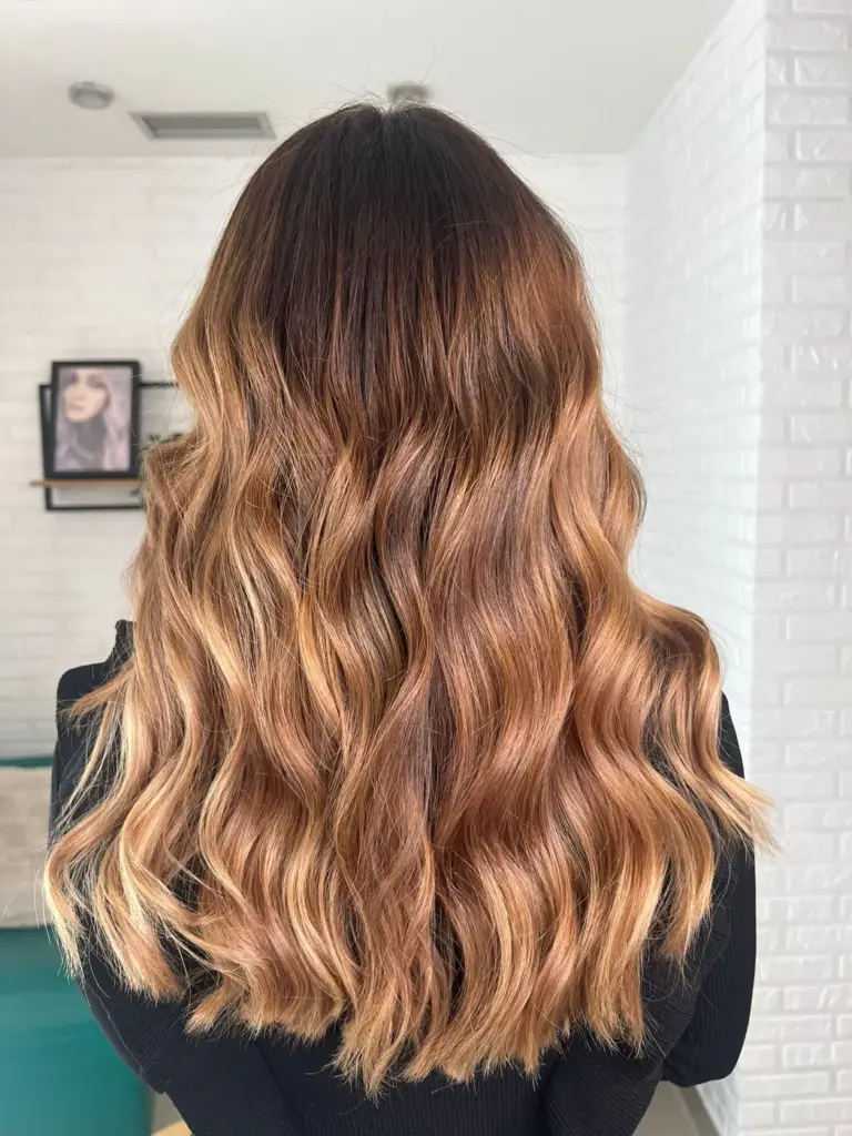 Balayage caramelo con ondas sobre melena larga